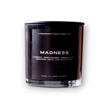 A sleek black luxury candle with "madness" text and a description of aromatic notes including currant noir, orange tangerine, cranberry woods, sandalwood, vanilla, plum Brand Name: Predominantly Black