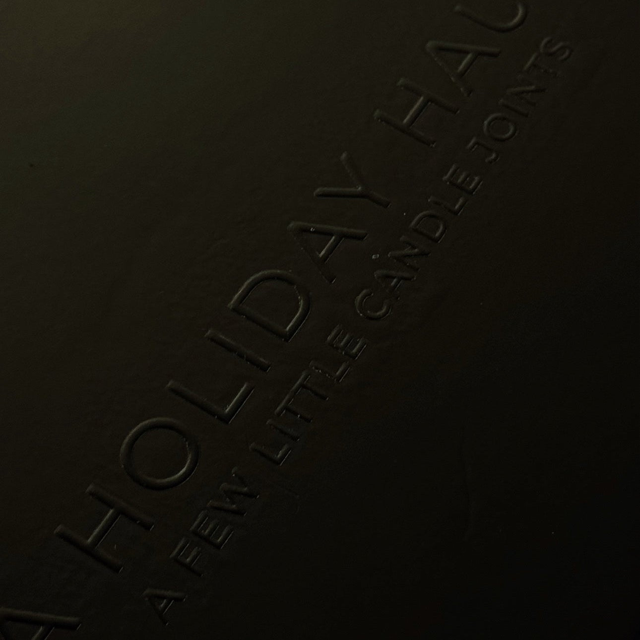 Dark surface with 'Holiday Haus' branding embossed on it