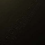 Dark surface with 'Holiday Haus' branding embossed on it