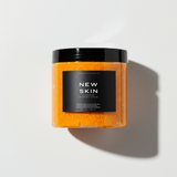 Skin Maintenance System: NEW SKIN foaming turmeric body scrub jar in sunlight — Predominantly Black
