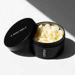 Open OPEN scented wax melt tin with yellow pieces; sea salt and jasmine fragrance — Predominantly Black