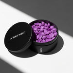 Open SUBTLE scented wax melt tin with purple pieces; coconut and vanilla fragrance — Predominantly Black