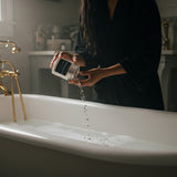 GOODNIGHT Bath Salts for Evening Wind-Down: person sitting beside a bathtub; lavender fragrance — Predominantly Black