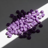 SUBTLE Wax Melt: purple scented wax melt pieces on white; coconut and vanilla fragrance — Predominantly Black