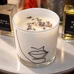 SOLITUDE illustrated soy-coconut scented candle styled beside facial oils; sage and lavender fragrance — Predominantly Black