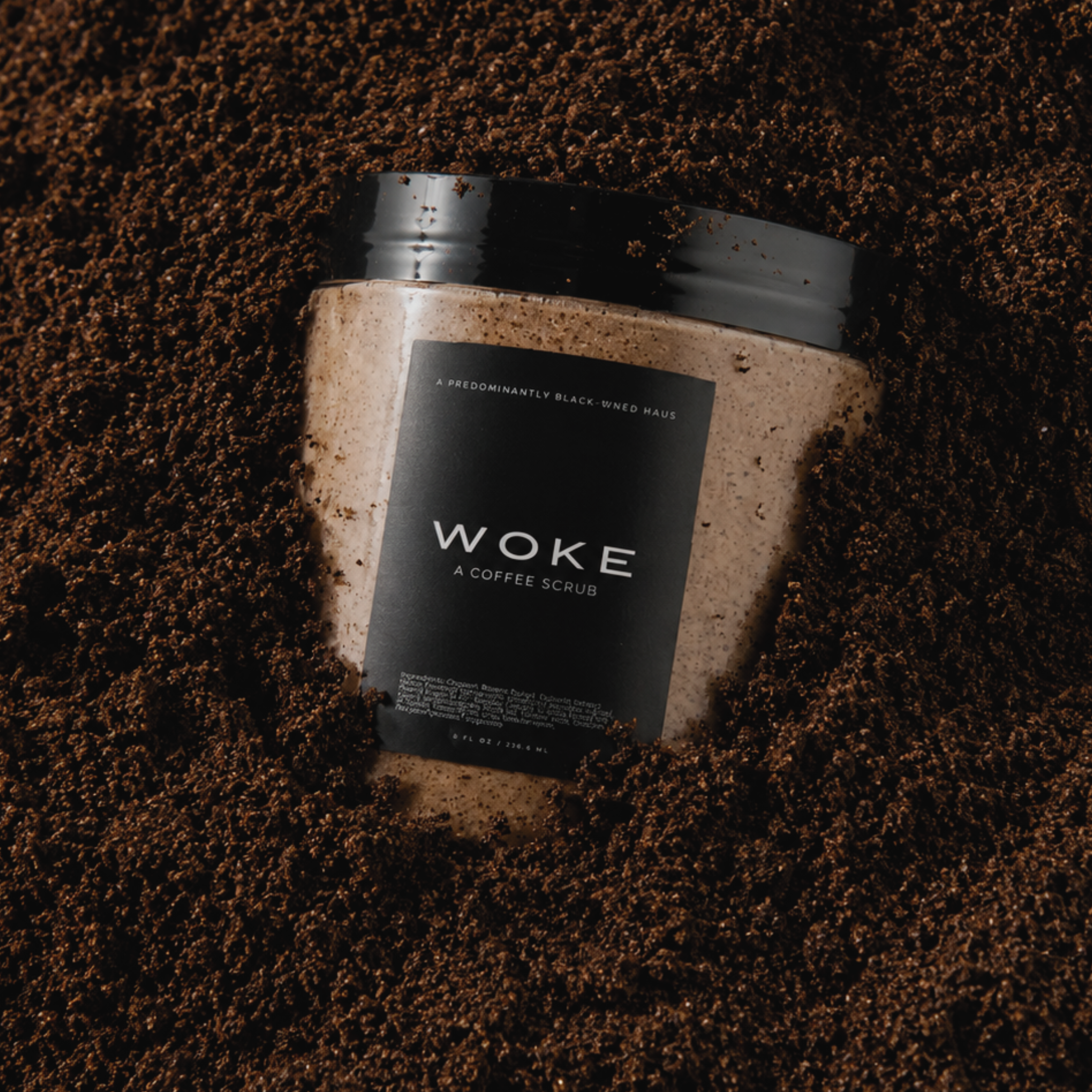 WOKE scrub jar resting on coffee grounds — Predominantly Black