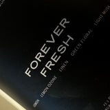 Close-up of FOREVER FRESH candle label; lemon and clean linen fragrance — Predominantly Black